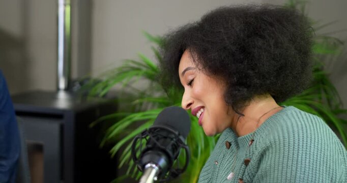 African American woman recording podcast into mic in green sweater moving from animated to quiet
