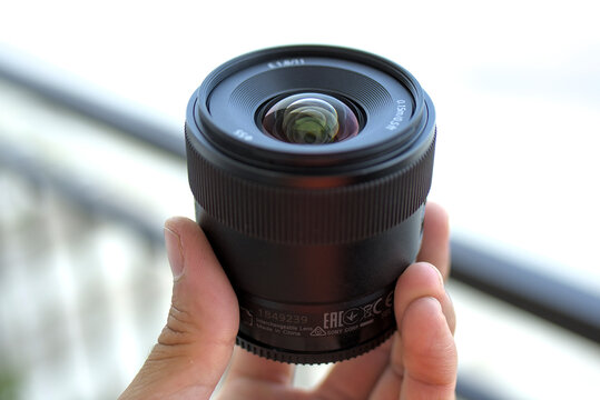ZAPOPAN, MEXICO - AUGUST 20, 2026: Hand holding a Sony E 11mm F1.8 lens.