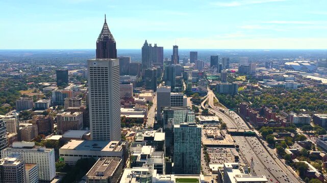 Downtown Atlanta cityscape with urban highways, driving cars and surrounding skyscraper buildings. Speed, progress and city connectivity concept.