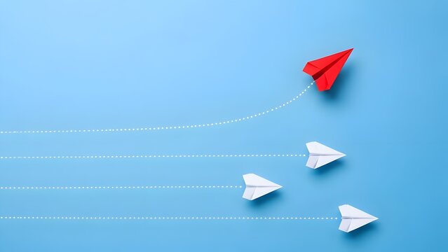 Red paper airplane changing direction and leading a group of white planes on blue background, illustrating innovation, business leadership, and new strategy.