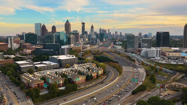 Urban Atlanta cityscape with modern skyscraper buildings and driving traffic on elevated interstate highways. American transportation system and metropolitan mobility.