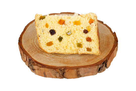 Slice of Christmas panettone with candied fruit and raisins on a rustic wooden base, isolated on a white background