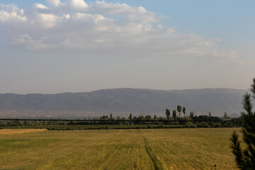 Naklejka premium Rural farmland with mountains in the distance in Tajikistan