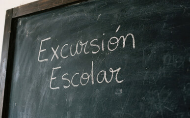 Fototapeta premium Excursion Escolar escrito con tiza en pizarra para anunciar viaje educativo y actividades