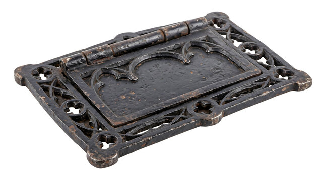 Ornate wrought iron gothic door flap for mail slot with dark weathered texture provides historical architectural hardware detail for residential house entrance.