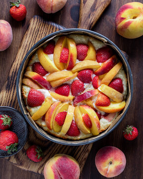 Top down view of a prepared strawberry peach cake ready for baking.