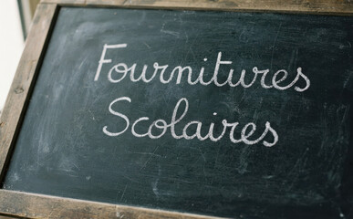 Fototapeta premium Fournitures Scolaires ecrite a la craie sur un tableau noir ecole education rentree