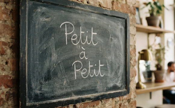 Petit a Petit tableau noir cafe inscription ecriture manuelle decoration murale concept de motivation et patience
