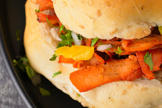 Closer view of traditional Mexican cemita sandwich with red meat and ingredients