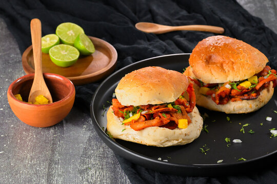 Gourmet Mexican-style al pastor torta or cemita al pastor with marinated pork, pineapple, onion, cilantro, and limes