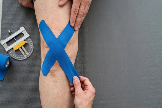 Blue tape on a knee, showcasing a physical therapy application for rehabilitation during National Physical Therapy Month