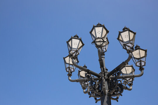 Beautiful lamp post stands tall in vibrant city square. Vintage architecture adds charm