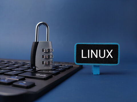 A combination padlock rests on a black keyboard next to a LINUX sign on a blue background