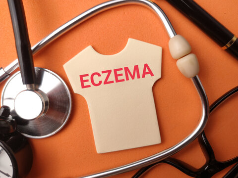 A shirt-shaped cutout labeled ECZEMA sits framed by a stethoscope, clock, glasses, and pen on orange