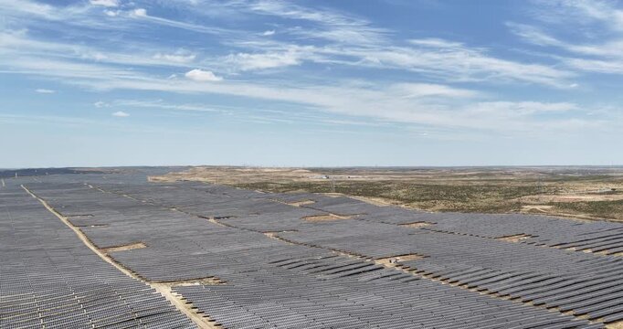 Aerial footage of Vast Solar Photovoltaic Farm Stretching Across Gobi Desert Under Blue Sky