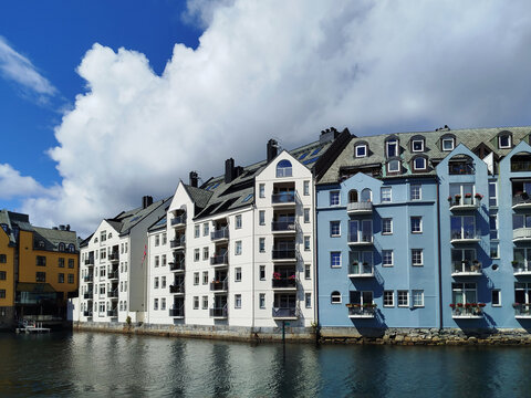 Colorful Art Nouveau architecture by the water in &Aring;lesund, Norway. Historic Scandinavian buildings near the harbor under a cloudy sky.