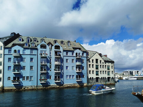 Colorful Art Nouveau architecture by the water in &Aring;lesund, Norway. Historic Scandinavian buildings near the harbor under a cloudy sky.