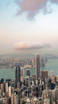 Time-lapse of Hong Kong skyline from Victoria Peak, transitioning from sunny afternoon to glowing blue hour.