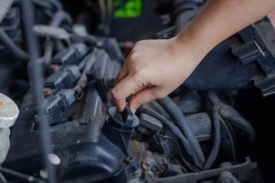 Close up of a  hand of woman is open the engine oil pan cover