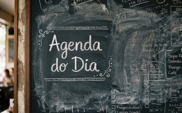 Agenda do Dia escrita em lousa com giz representando planejamento diario, organizacao e rotina de trabalho em restaurante ou escritorio
