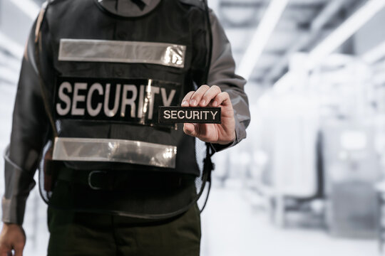 Security guard in protective vest an identification badge in a bright modern office lobby, representing access control and workplace safety