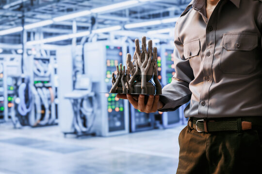 Technician holds 3D print plate with glowing digital hand models in a modern data center, automation, artificial intelligence, and advanced technology.