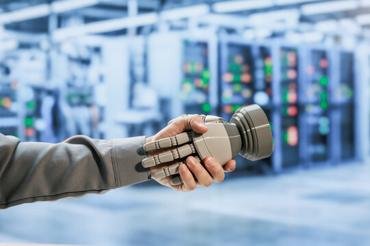 Human and robotic hands shaking in a modern data center, partnership between people and artificial intelligence technology.