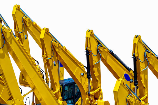 Rows of yellow hydraulic excavators with powerful boom arms parked at heavy equipment yard. Construction machinery, civil engineering, industrial technology and infrastructure development.