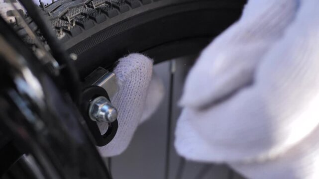 Bicycle mechanic adjusting front caliper brake with wrench close up
