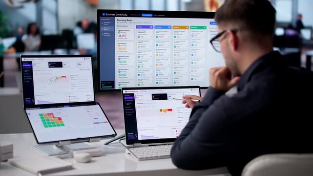Risk Manager Analyzing Compliance Data On Dual Screen Laptop