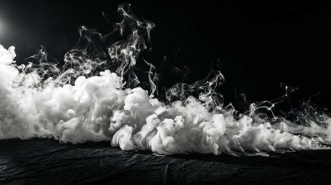 White smoke swirls and spreads across a dark surface