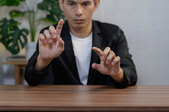 Man Demonstrating Gesture with Hands in Formal Attire at Table