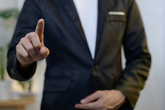 Businessman in Black Suit Pointing Gesture Indoors with Confidence