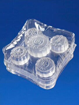 A luxurious traditional Chinese mooncake gift box recreated as a transparent inflatable plastic sculpture, rectangular box with rounded inflated edges, several translucent mooncakes visible inside