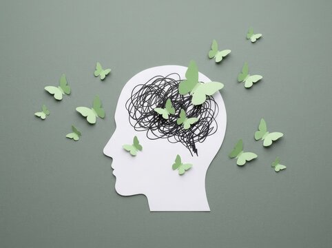 Conceptual paper art of a human head with butterflies for world mental health day awareness campaign