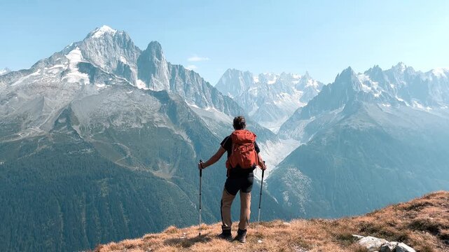 Hiker standing on mountain summit overlooking mont blanc range in france, Alps mountain