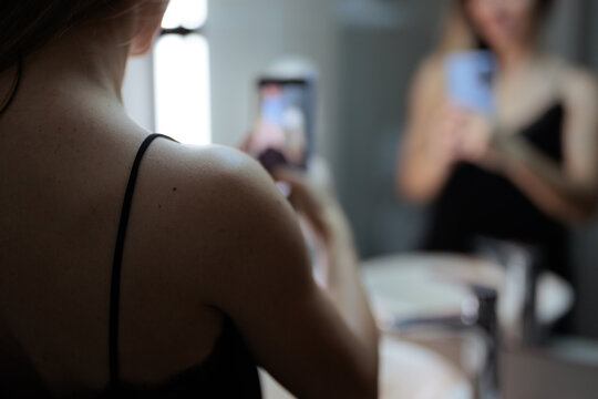 Young Woman Taking Mirror Selfie Photo With Smartphone Sending Message To Boyfriend. Close up view of a girl taking reflection selfie with phone for her partner 