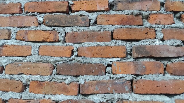 Rustic Red Brick Wall with Weathered Texture and Repeating Pattern