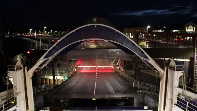 Helsingor, Denmark A roll-on/roll-off car ferry to Sweden at night loads from a movable bow section and departs from the dock. 