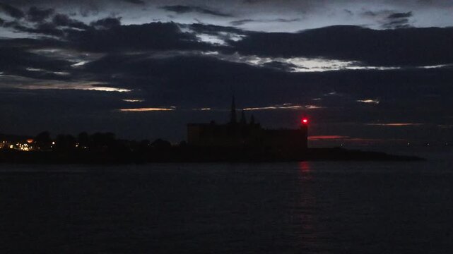 Helsingor, Denmark A night view on the Oresund of the Kronborg Castle with a blinking red navigation light. 