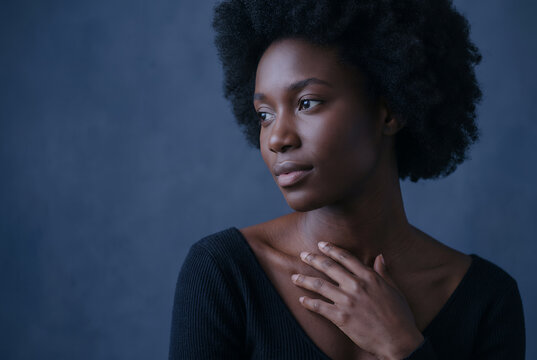 Woman profile portrait looking serene contemplative blue studio background