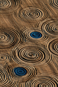 Circles carved in earth spiral outward from deep blue centers