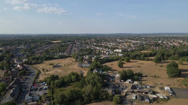 Cinematic drone flyover of Uxbridge with wide views of residential districts and surrounding countryside edges. This shot presents the town&rsquo;s layout and its place within Greater London&rsquo;s suburban area