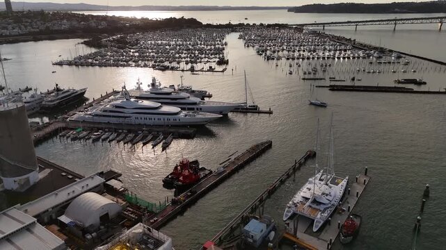 Luxury superyachts in Westhaven Marina and Auckland Harbour Bridge in Auckland, New Zealand. Aerial drone view
