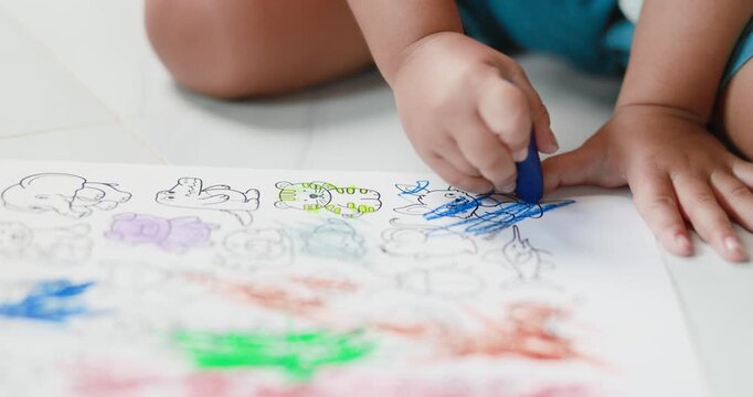 Child coloring with crayons on paper, art activity, creativity, early childhood education, learning, imagination, and child development, close-up