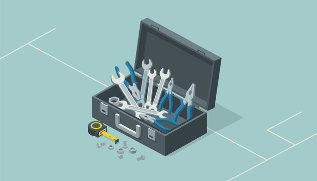 Open metal toolbox filled with various hand tools such as wrenches and pliers placed next to a tape measure on a light blue surface.