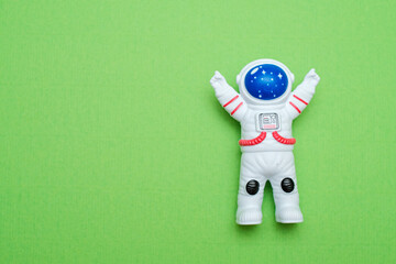 Small astronaut figurine on a coloured background. Symbolizing space exploration, travel, and dreams. Ideal for concepts of innovation, future and childhood wonder © MY STOCKERS