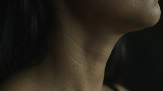 Moody Cinematic Low Key Profile of Woman Neck and Nape with Subtle Swallowing Motion