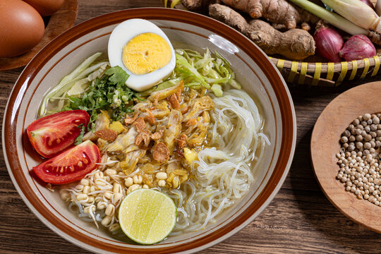 Authentic indonesian soto ayam chicken soup with glass noodles boiled egg fresh lime and raw traditional spices