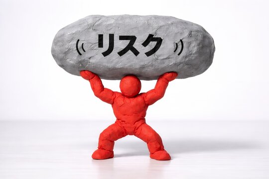 リスクと書かれた巨大な岩を持ち上げる人物が重い責任や危険を背負う状況を象徴するイメージ